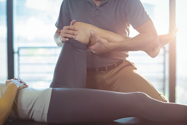 Physical Therapist stretching someone's leg